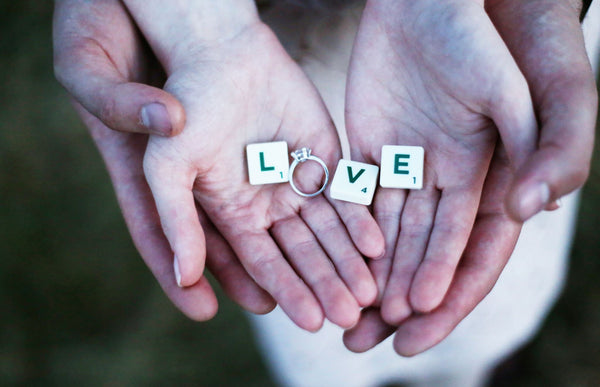 Just Gold Jewellery - man and womans hands holding an engagement ring