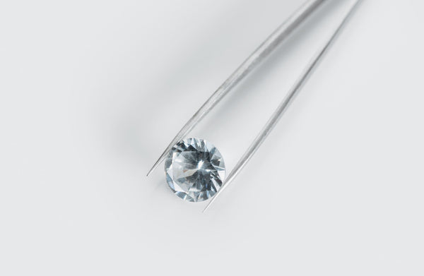 Just Gold Jewellery - top view of shiny diamond in tweezers